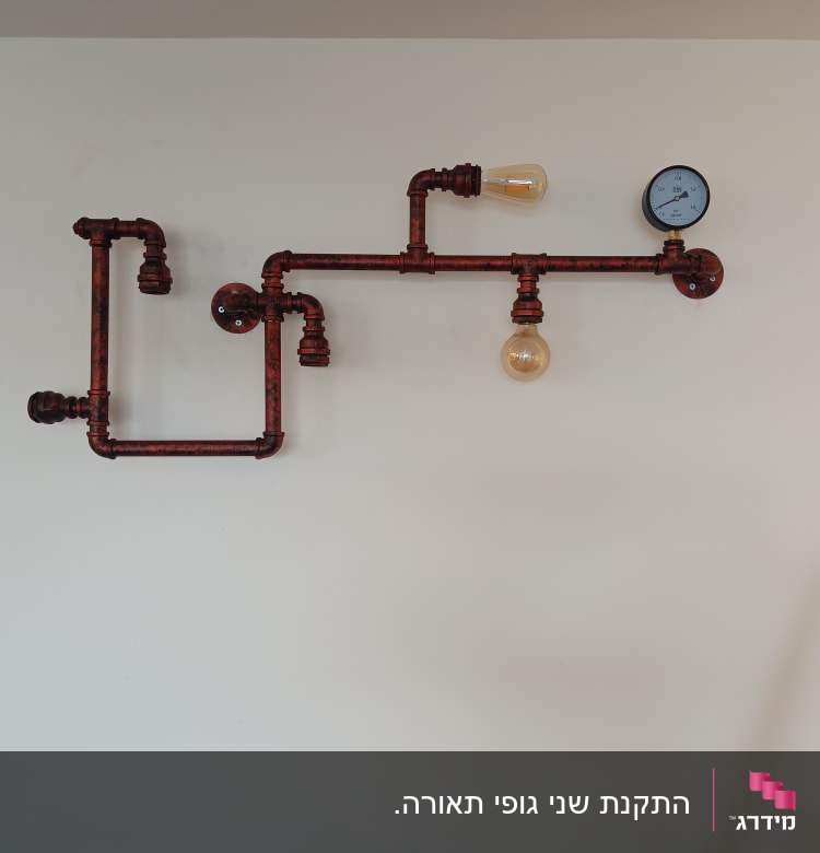 צינורות מתכת עם נורות ומד לחץ על קיר